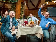 Мужчины за столом с поднятыми айфонами в руках